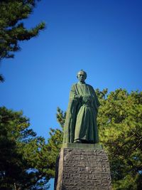 Low angle view of statue against clear blue sky