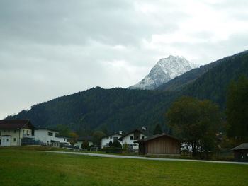 Houses by mountains against sky