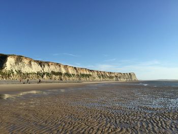 Scenic view of beach against blue sky