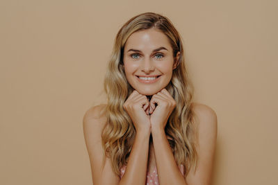 Portrait of young woman against wall