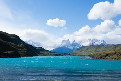 Scenic view of sea by mountains against sky