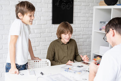 Young boys and having fun constructing robot cars together at the workshop