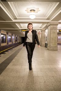 Portrait of beautiful young woman walking on subway station platform