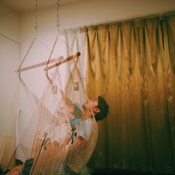 Multiple image of man sitting on swing at home