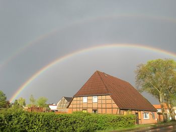 Rainbow over building against sky