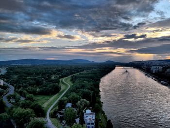 High angle view of river amidst city against sky at sunset