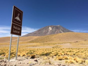 Information sign on desert against sky