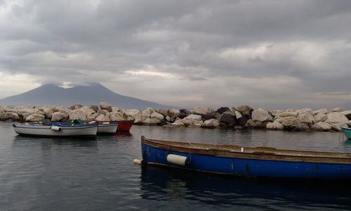 Boats moored in sea against sky