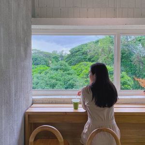 Woman sitting by window