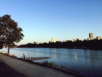 Scenic view of river by city against clear blue sky