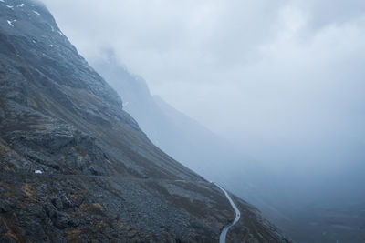 Rocky mountainside with road and mist. distant. panoramic.