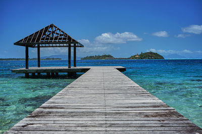 Wooden pier on sea against sky