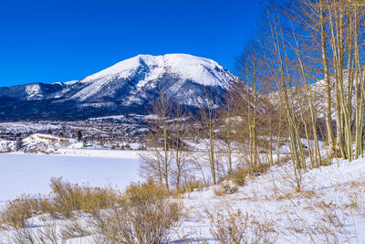 Scenic view of snowcapped mountains against clear blue sky