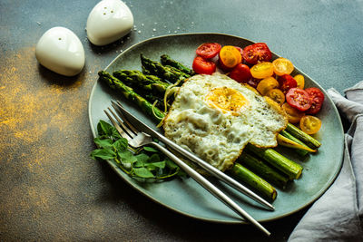 Organic grilled asparagus served for healthy keto lunch on stone background with copy space