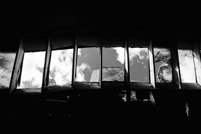 Silhouette trees against sky seen through window
