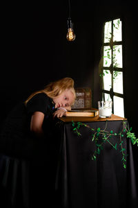 Side view of woman looking through window