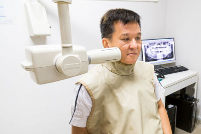 Mature man examined by dental equipment