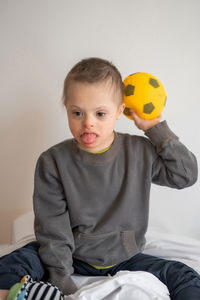 Portrait of cute baby boy sitting on sofa at home