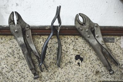 Various hand tools hanging on wall at workshop