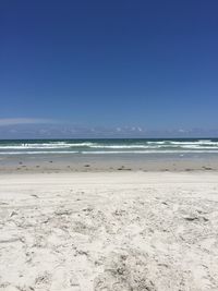 Scenic view of beach against blue sky