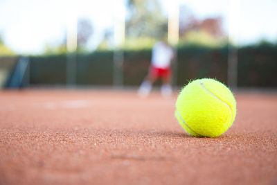 Close-up of yellow ball on tennis field