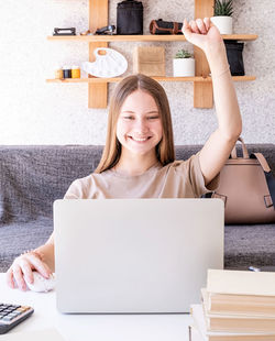 Portrait of a smiling young woman using phone