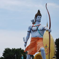 Low angle view of statue against building against sky