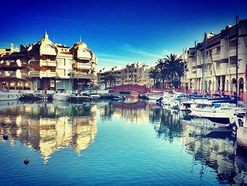 Boats in river with buildings in background