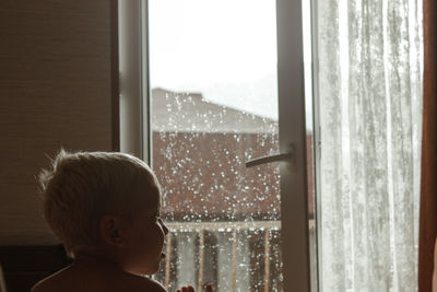 Portrait of a boy looking to the side on a rainy day