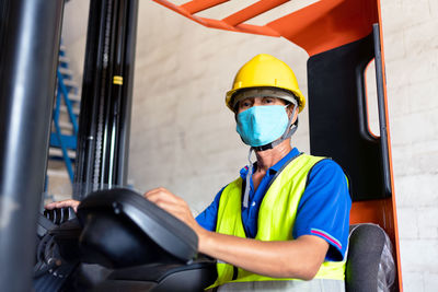 Portrait of worker wearing hardhat and mask