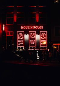 Illuminated sign on street at night