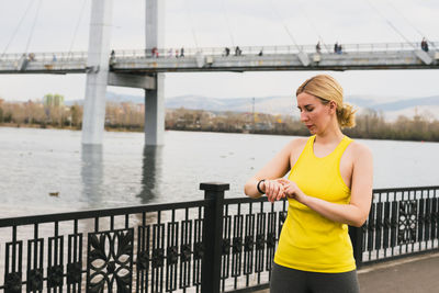 Young woman standing on bridge over river