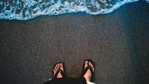 Low section of woman standing on beach