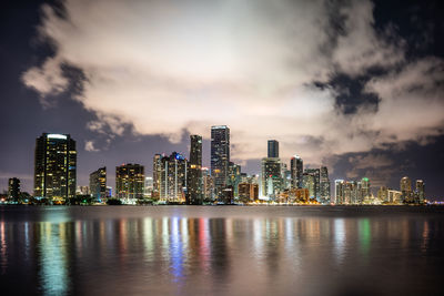 Illuminated buildings in city against sky at night