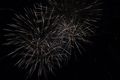 Low angle view of firework display at night