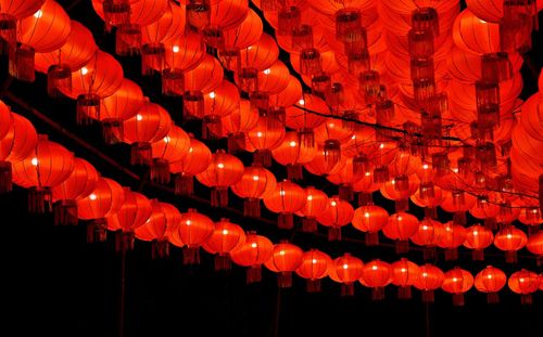 Low angle view of illuminated lanterns hanging at night