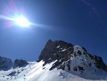 Scenic view of snowcapped mountains against sky on sunny day