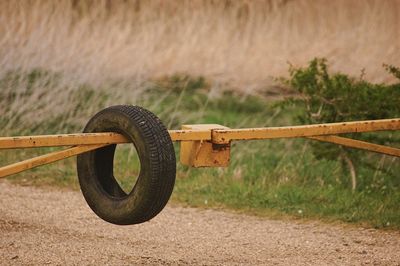 Close-up of rusty wheel on field