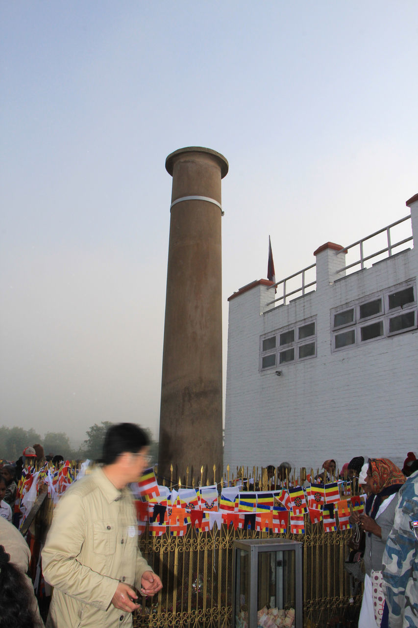 PEOPLE ON BUILDING AGAINST CLEAR SKY