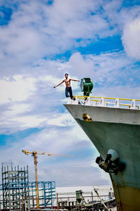 Low angle view of shirtless man jumping from boat against sky