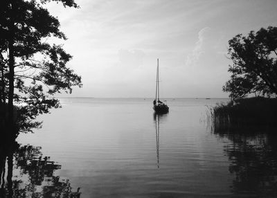 Boat sailing on lake against sky