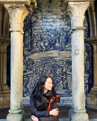 Full length of woman sitting outside building