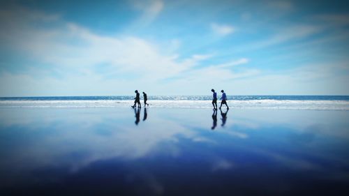 People on beach against sky