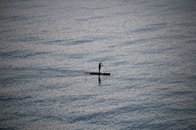Silhouette person on boat in sea