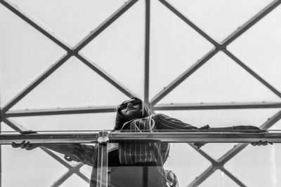 Low angle view of woman standing by railing 