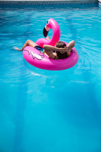 Man relaxing in inflatable ring on swimming pool