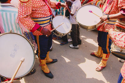 Low section of musicians playing drums on street