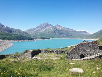 Scenic view of lake and mountains against clear blue sky