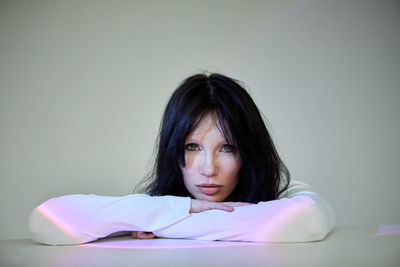 Portrait of young woman sitting on bed at home