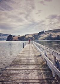 Scenic view of pier on lake against sky